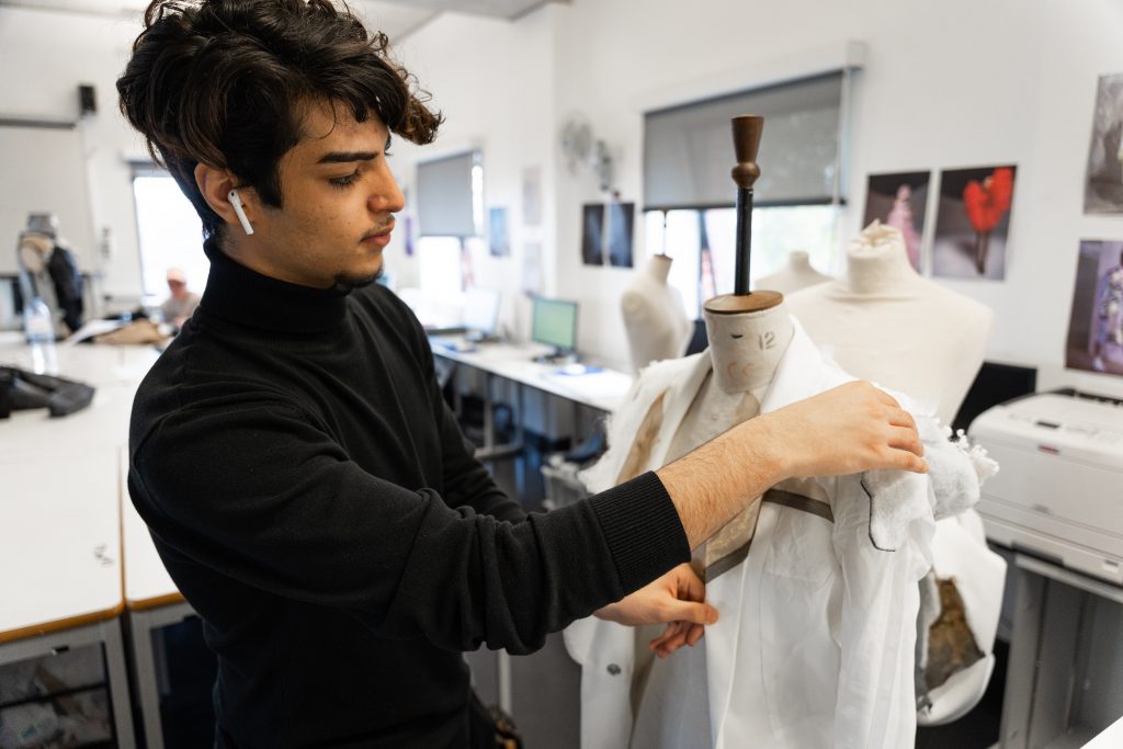 Young man in fashion studio working on design